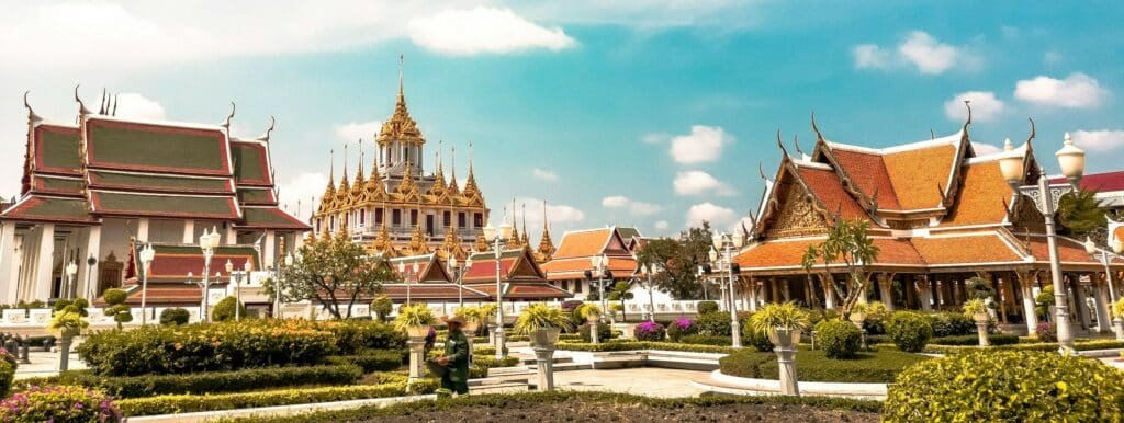 Loha Prasat em Bangkok, na Tailândia, um complexo de templos tradicionais tailandeses com telhados vermelhos e detalhes dourados em um dia ensolarado, os edifícios apresentam uma arquitetura ornamentada com várias torres pontiagudas. Representa eSIM Bangkok.