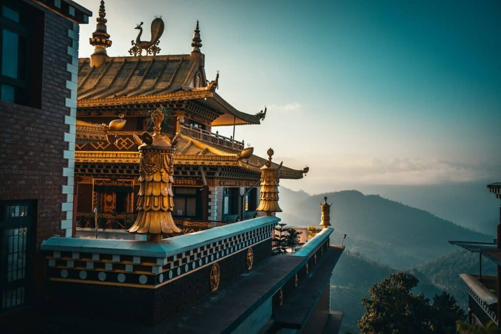 vista do Monastério Thrangu Tashi Choling, no Nepal, um dos países da Ásia, uma estrutura ao estilo pagode com detalhes em dourado e em meio a montanhas. Representa eSIM Nepal.